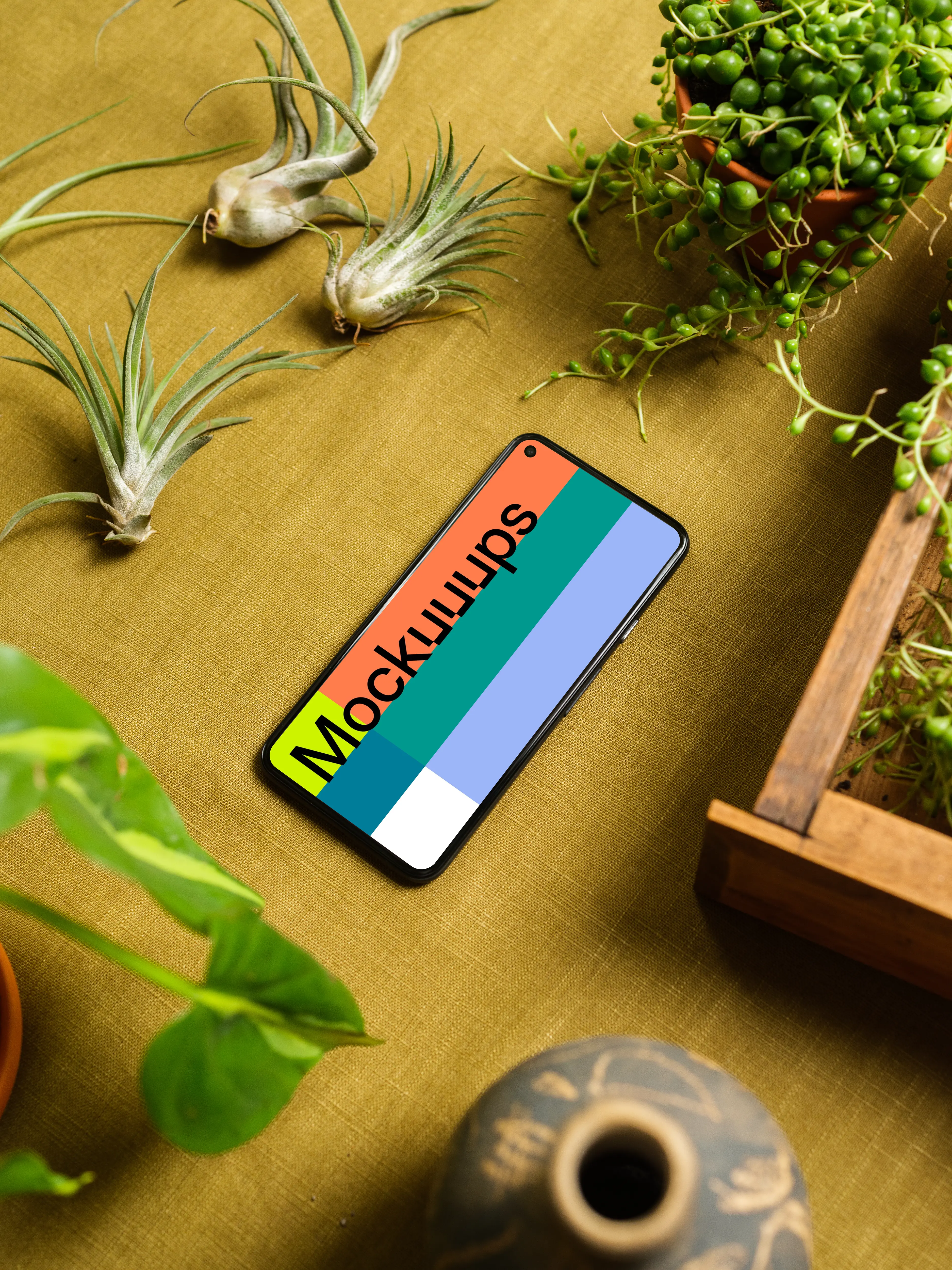 Pixel 5 mockup on a table beside a flower pot