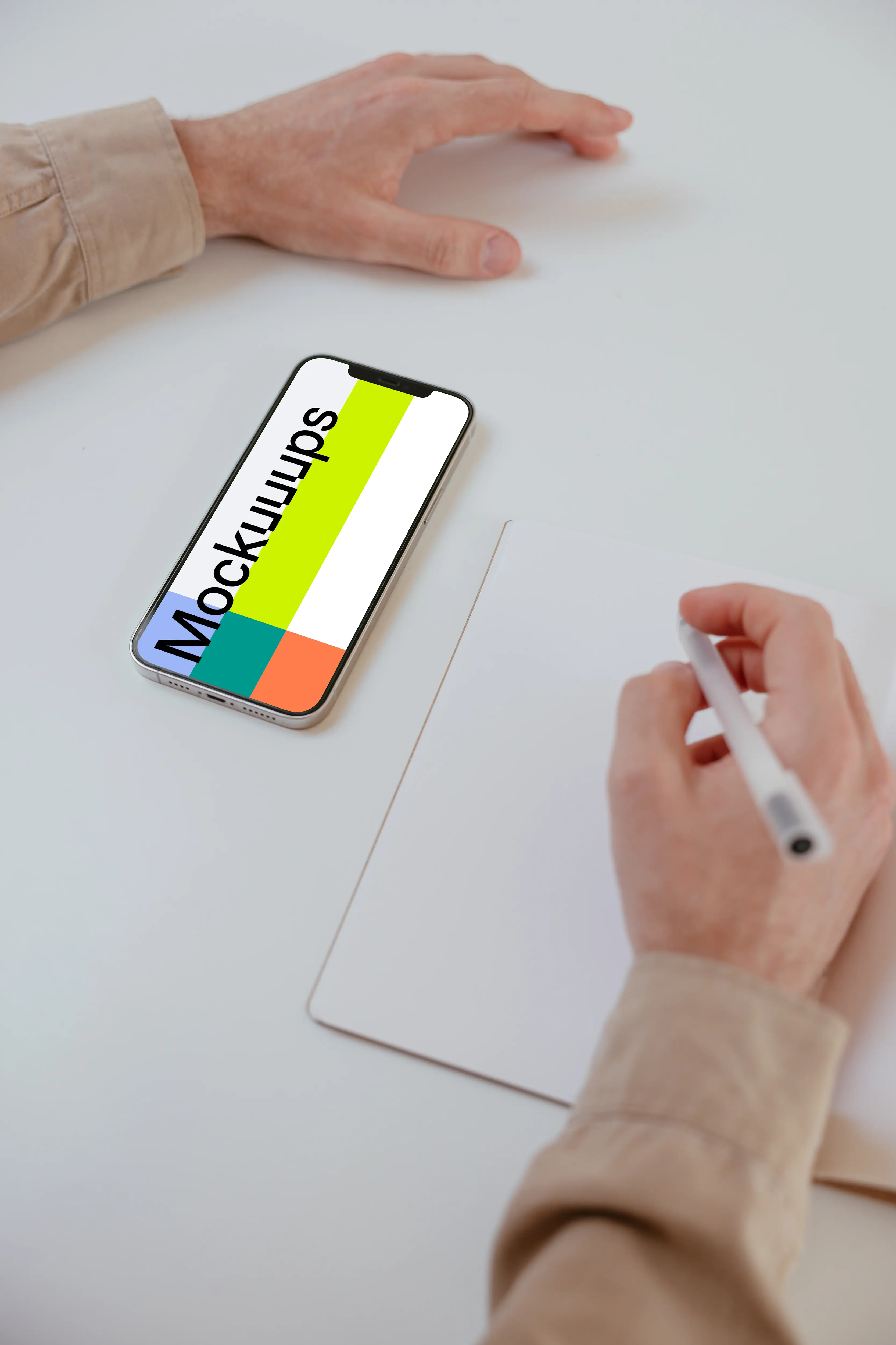 Simple iPhone mockup on a white table beside a book