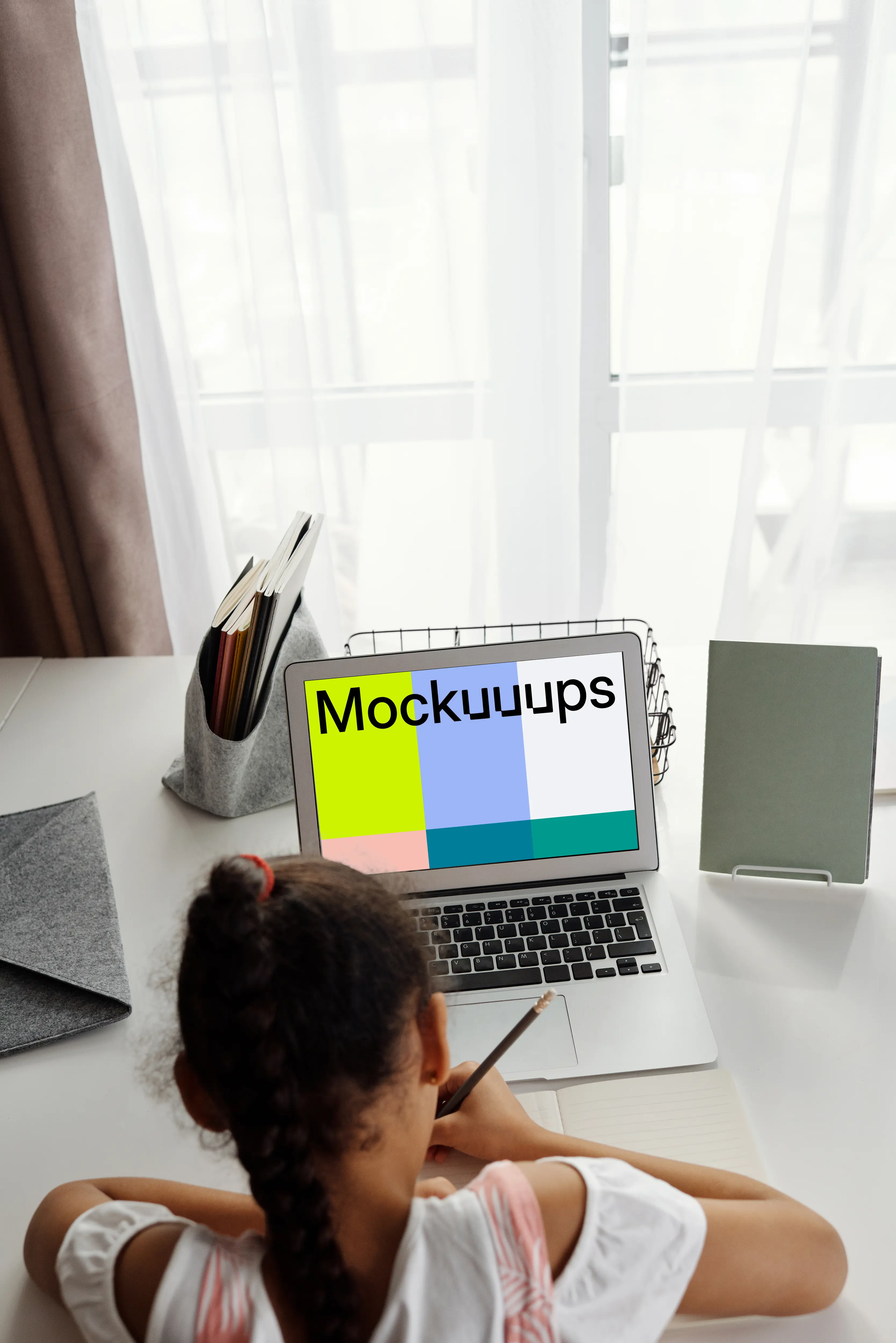 Young girl with ponytail studying with her MacBook Air mockup
