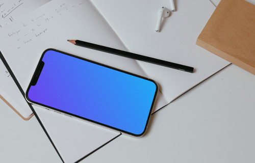 iPhone mockup on a table with books and a wireless keyboard by the side.