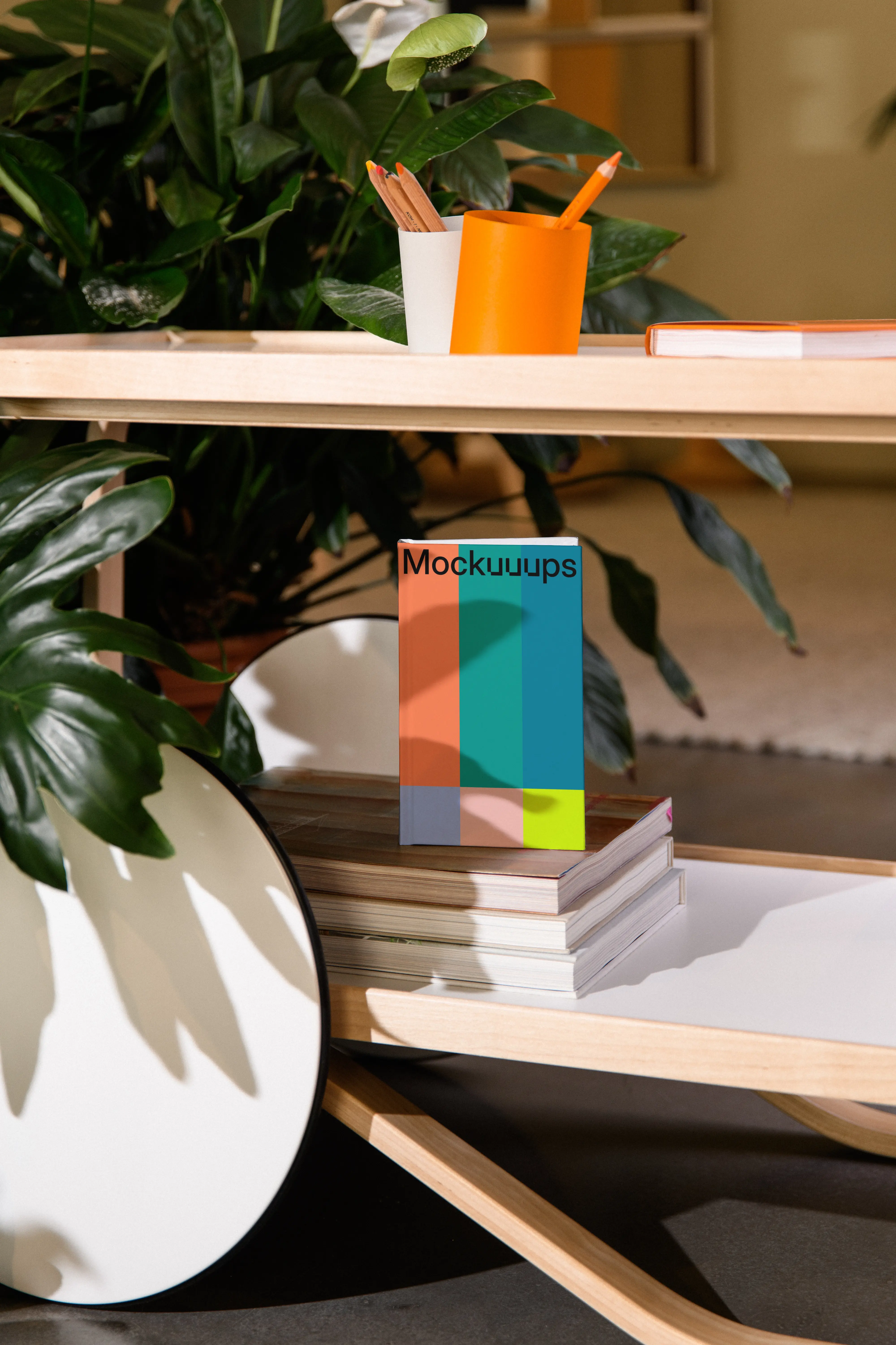 A-format book mockup on a wooden shelf with decor mockup