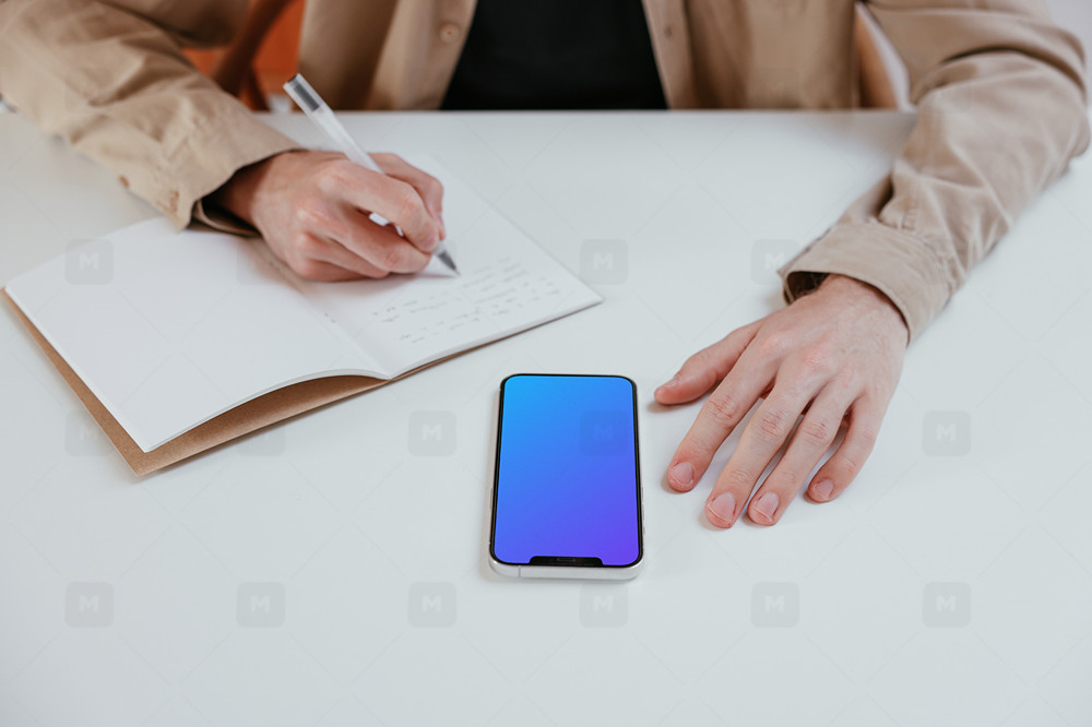 iPhone Figma mockup on a white table journaling