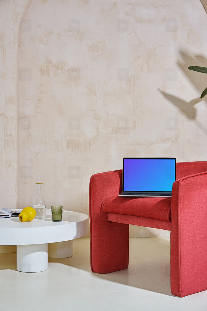 Macbook mockup on a red couch set in contemporary decor