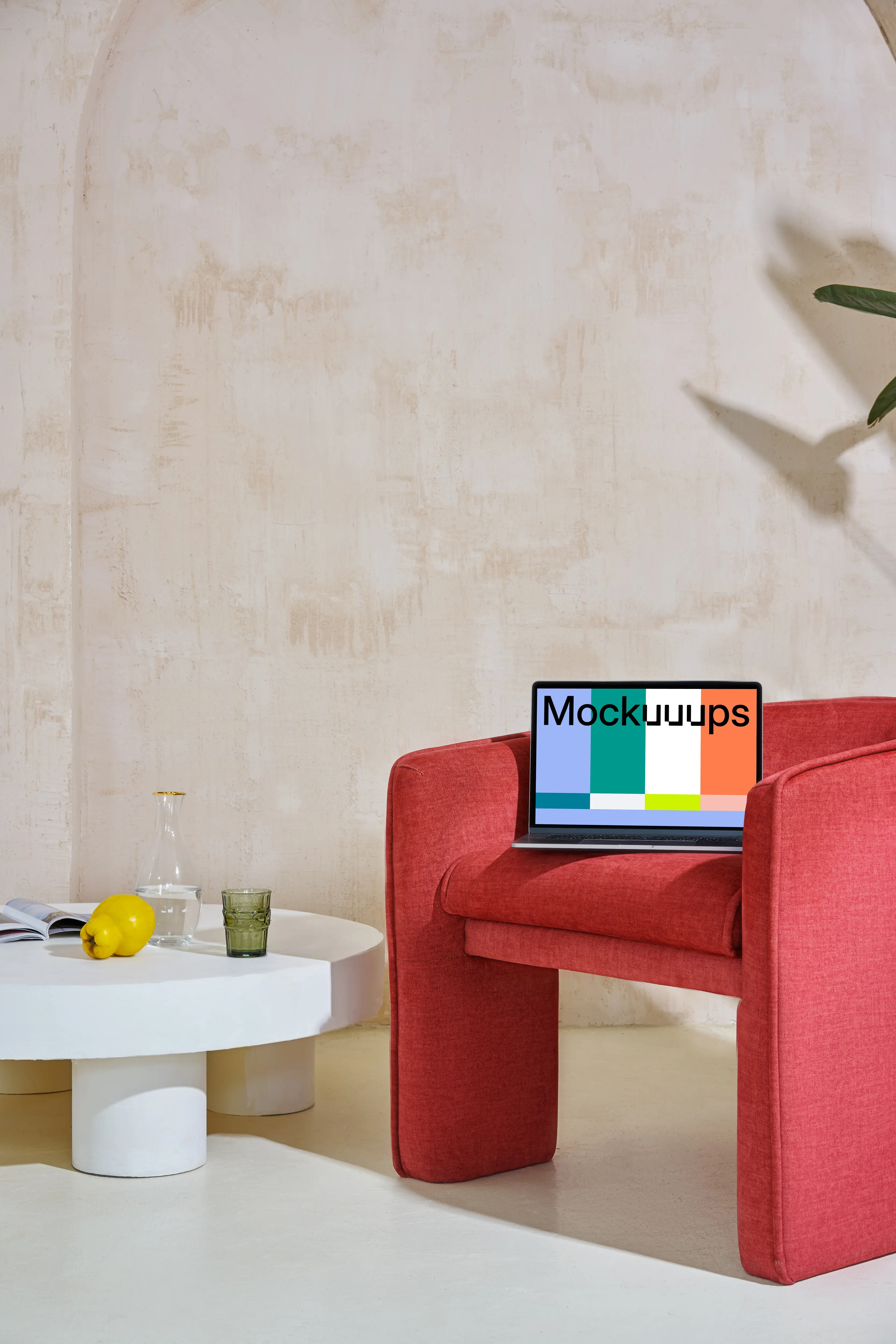 Macbook mockup on a red couch set in contemporary decor