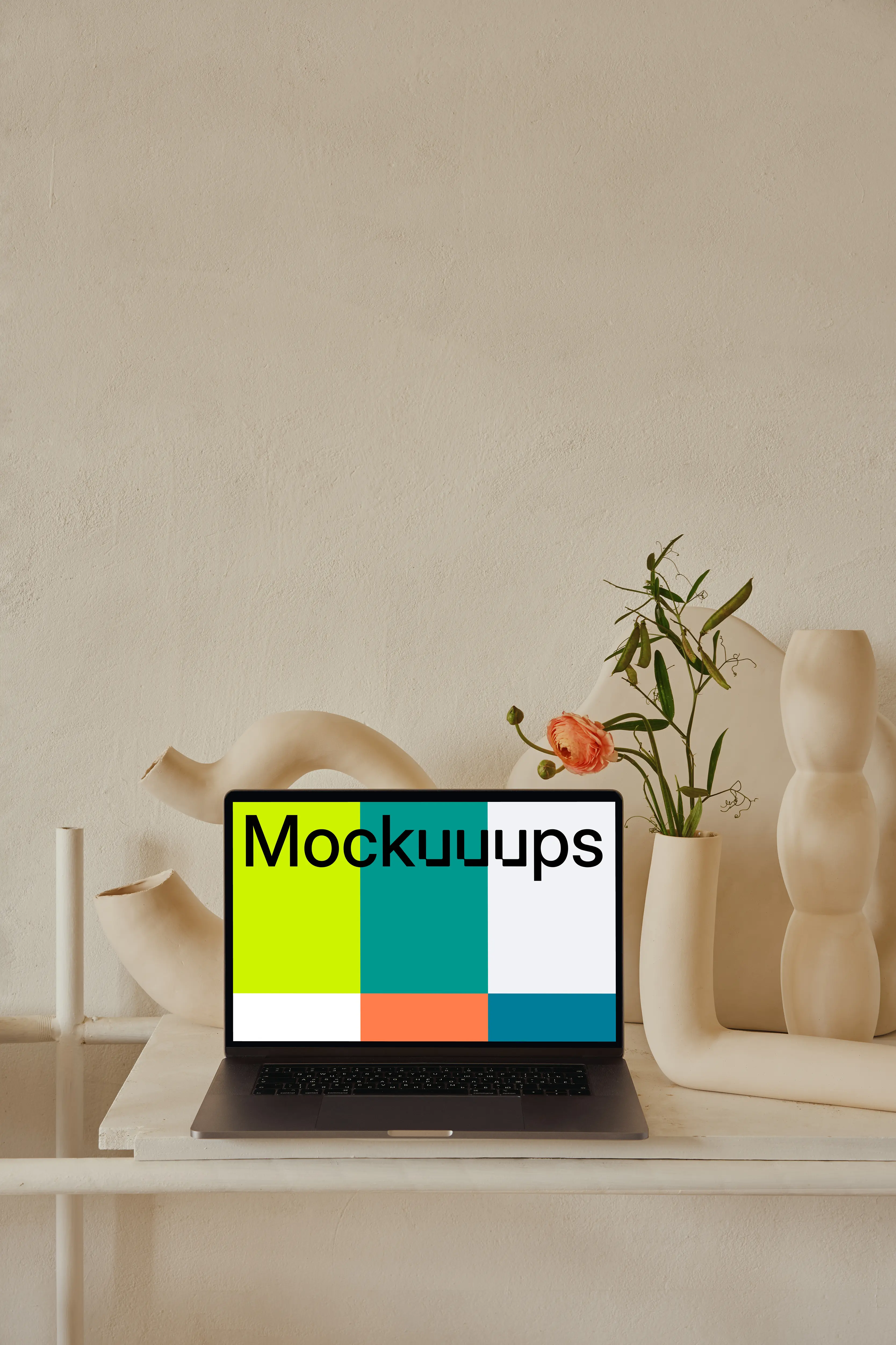 MacBook mockup on a peach colored table with a fancy flower vase