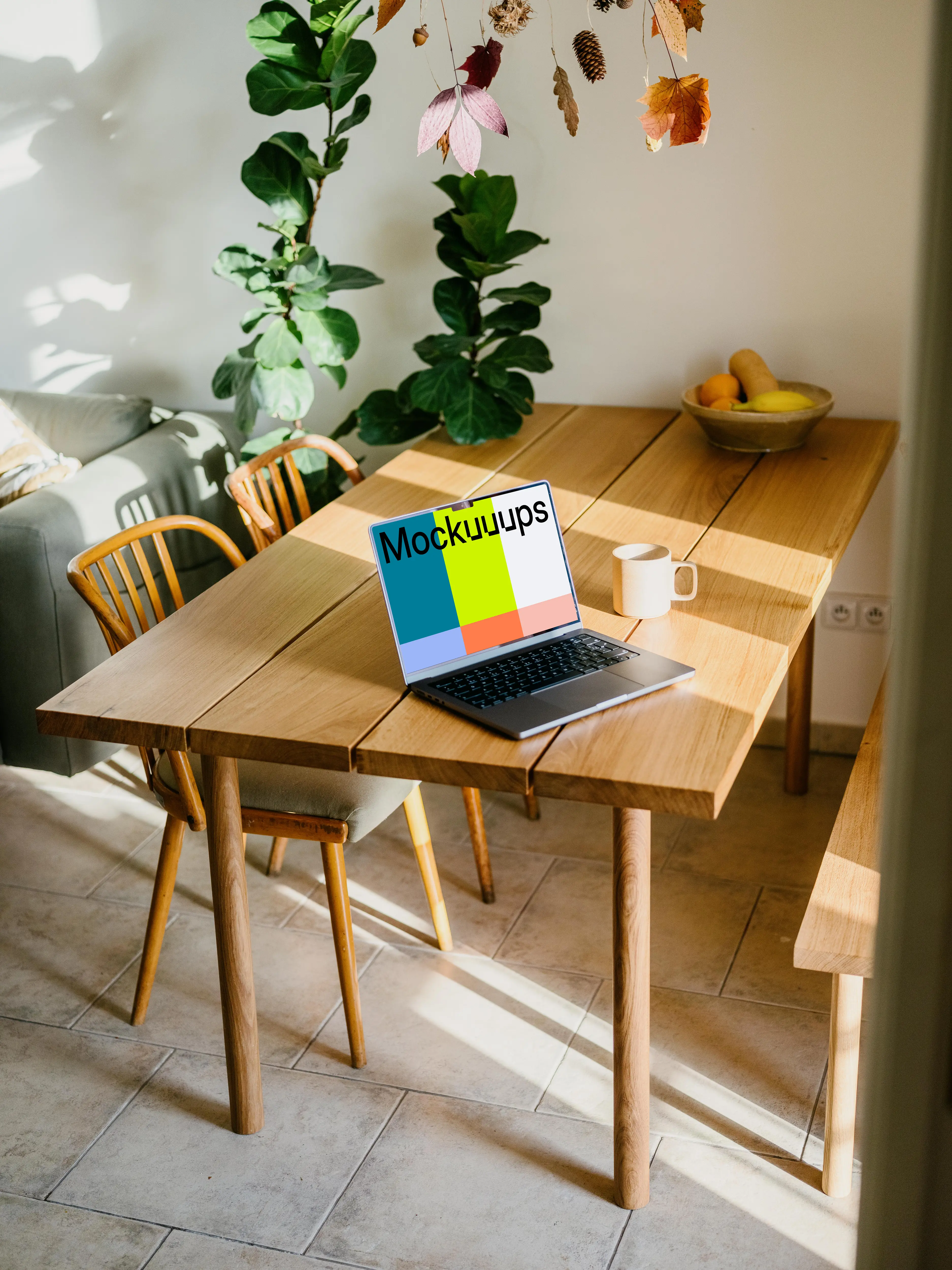 MacBook mockup on a table beside a coffee mug mockup
