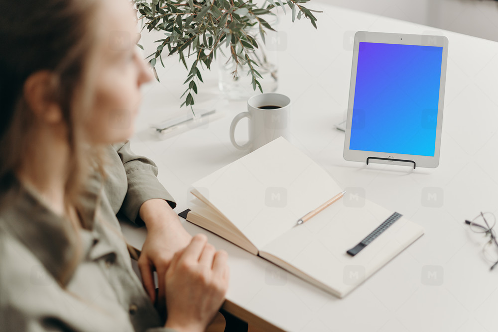 Tablet mockup on a white table with a diary at the side