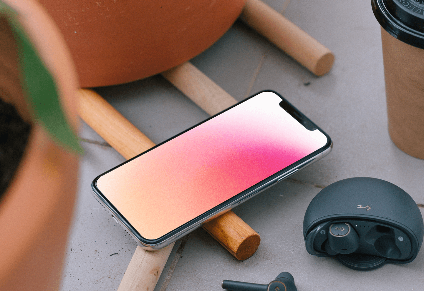 iPhone 12 mockup beside headphones